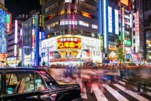 Long exposure showing blurred people crossing the street in Kabukicho, in front of the Donki